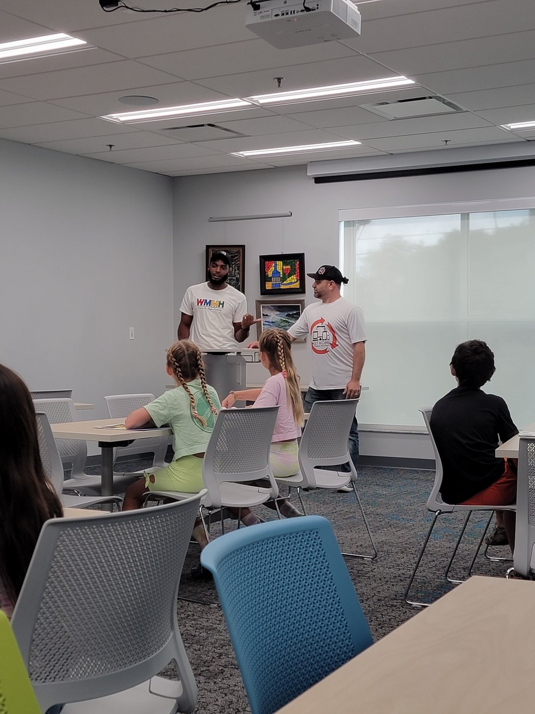 Thomas teaching WMMH financial literacy class to kids in a community room